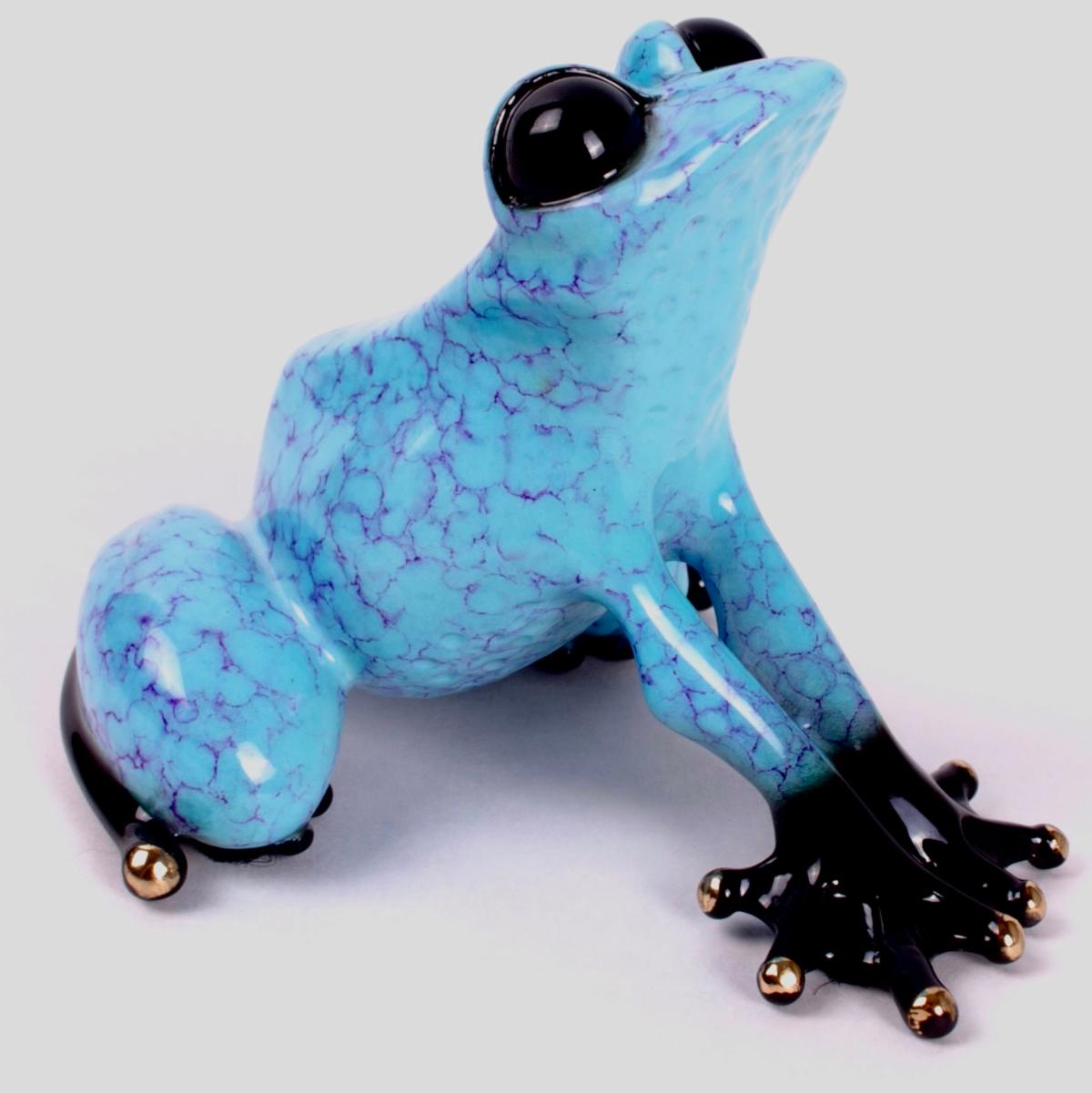 The Capri-inspired frog sculpture features a vibrant cracked pattern and sky-blue patina. Its shiny black feet and bulging black eyes contrast strikingly with the brilliant blue body, reminiscent of a Frogman piece, as it sits elegantly on a surface.