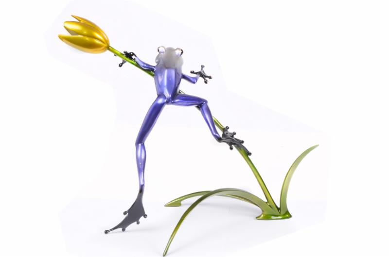 Back angle of a blue glass frog sculpture with a flower entitled Belle Fleur by Frogman at Marcus Ashley Gallery.