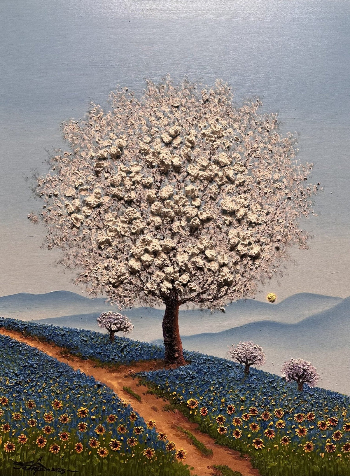 Blue Haze, an oil on canvas masterpiece by Mario Jung, features a white-blossomed tree on a hill with blue and yellow flowers, a winding path, three smaller flowering trees beneath a light blue sky, and soft hills.