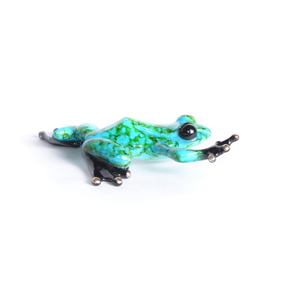 A vibrant glass sculpture by Tim Cotterill, also known as Frogman art, features Chase, a frog in bright turquoise with green speckles. It has black legs and toes, posed dynamically in a crouched position on a plain white background.