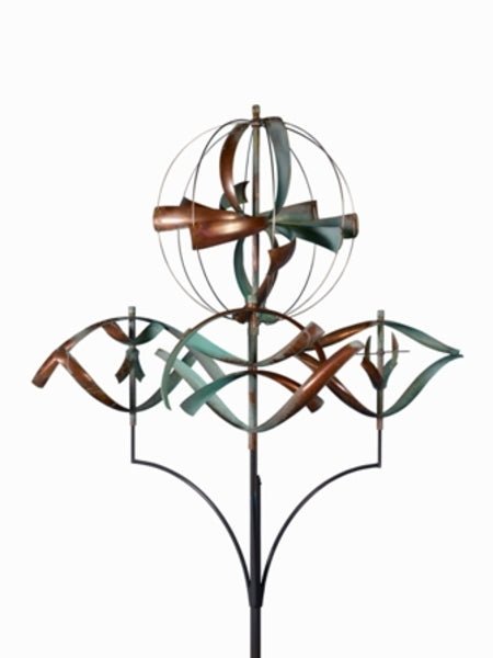 The Elements of the Universe kinetic sculpture features intertwined copper and teal ribbons reminiscent of Lyman Whitakers style. It highlights a spherical structure with curved elements, elegantly mounted on a black stand against a plain white background, capturing movement in stillness.