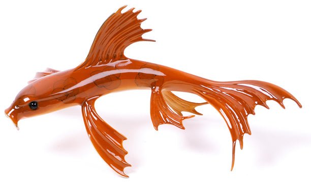 The Enforcer is a sleek, orange glass aquatic sculpture resembling a fantastical creature with large, flowing fins and a streamlined body. Its smooth surface reflects light, echoing the intricate artistry often found in Frogman Bronze designs.
