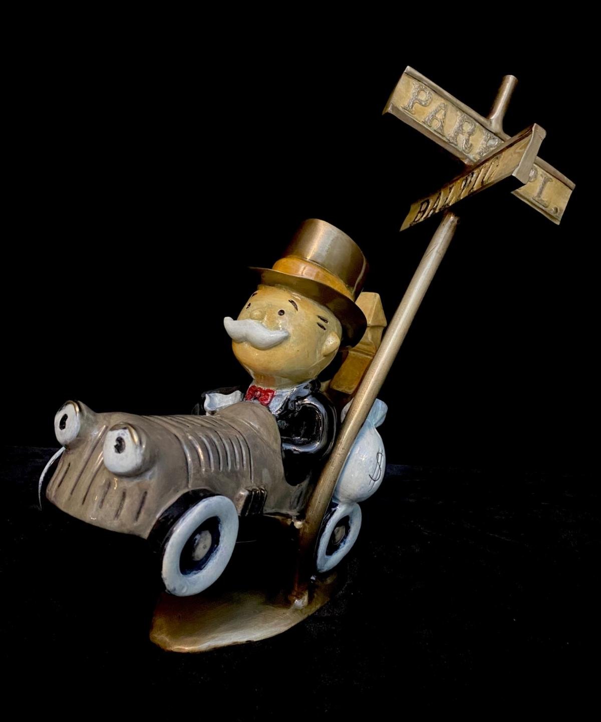 The whimsical Highway To Hell figurine by bronze sculptor Paul B. Lotz depicts a mustached character in a top hat driving a vintage car toward a gold sign for Park Place and Boardwalk on a mysterious black background.