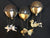I Believe presents three whimsical hot air balloons on a black background, each carrying an intricately detailed creature—a flying pig, a fish, and a bird—suspended by chains like bronze sculptures, capturing the playful spirit of Paul Lotzs art.