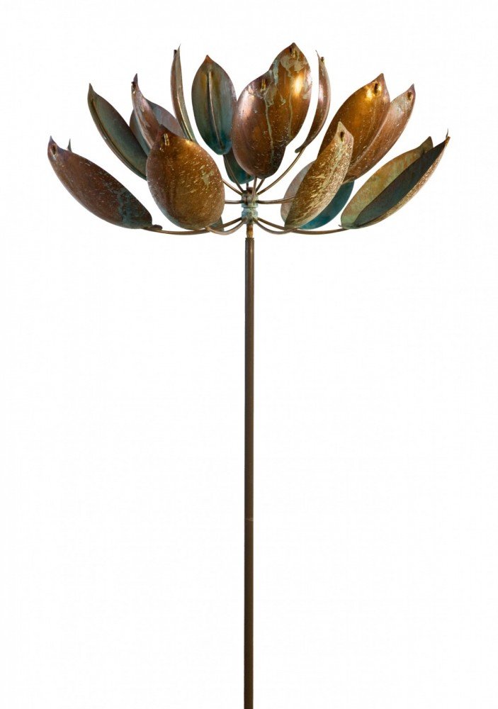 The metal sculpture Lotus resembles a large flower on a long stem, echoing Lyman Whitakers elegance. Its outward-curving petals feature weathered, rusted shades of brown and green, capturing contemporary wind sculpture essence against a plain white background.