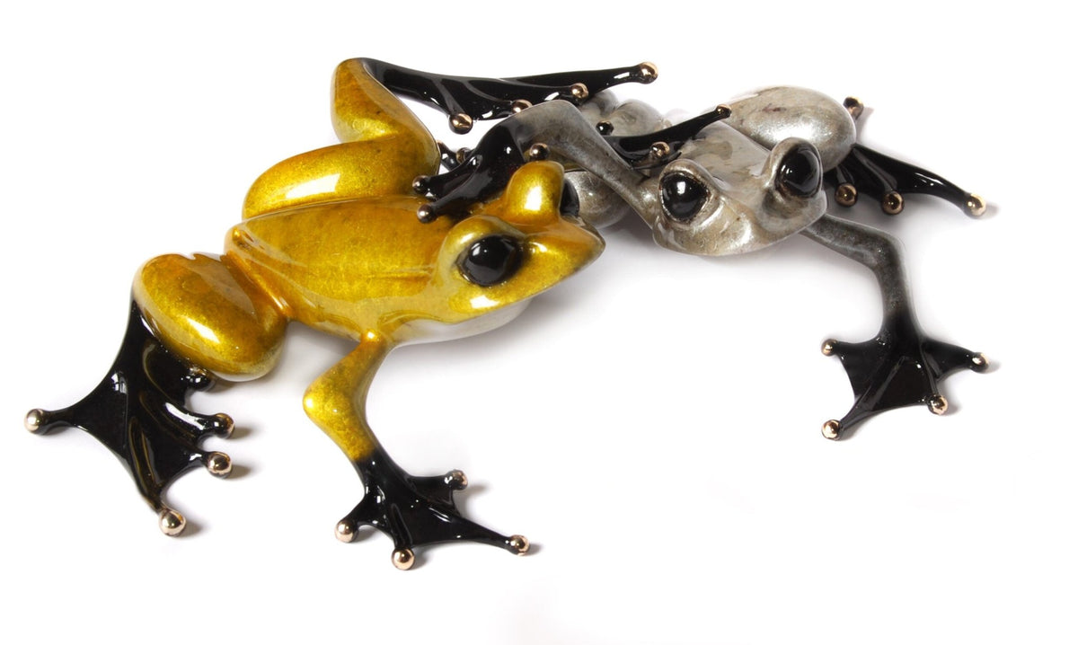 Two artistic Frogman sculptures, named Love by Tim Cotterill, are showcased, including a yellow bronze frog and a silver one. Featuring shiny, smooth surfaces with black feet, these expressive-eyed frogs are poised in mid-crawl on a white background.