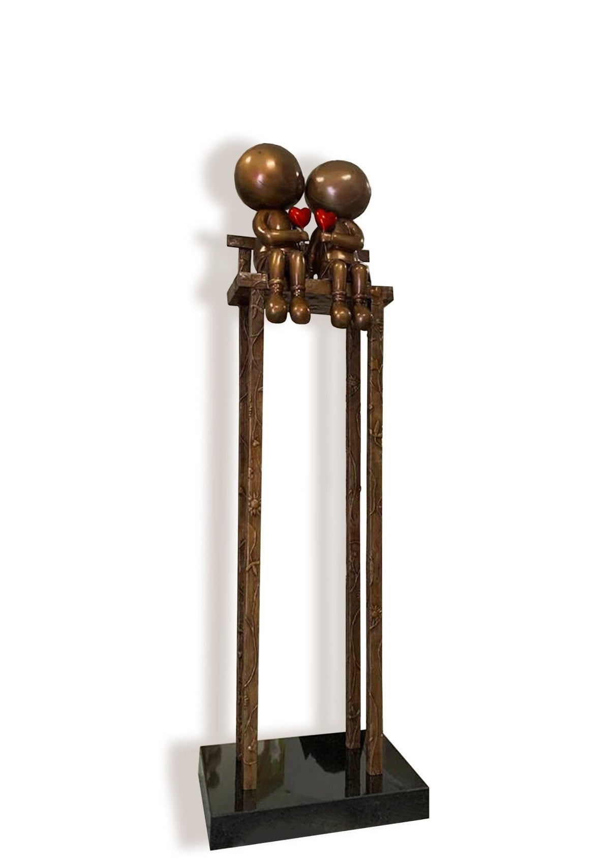 This Mackenzie Thorpe art piece, Lovers on the Bench, features two round-headed figures sharing an intimate moment on a tall platform. It is crafted in bronze tones with red heart details and has long, thin legs extending to a black base. Available at Marcus Ashley Gallery.