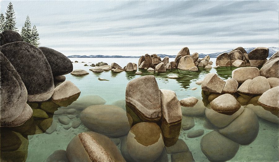 A serene Sand Harbor Time of Clarity scene with scattered large rocks partially submerged in clear water, resembling an Alexander Volkov piece. Distant mountains under a cloudy sky and pine trees on the left create a peaceful, natural setting.