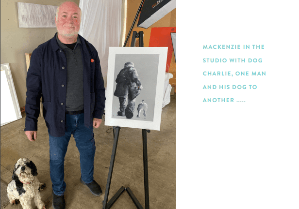 A man stands indoors beside an easel displaying a black-and-white photo of a man and a dog, with his curly-haired dog at his feet. Text on the right reads: Lets Go For A Walk—blending art and companionship in the studio.