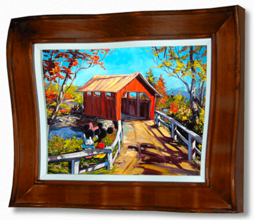 The Disney Limited Edition Colors of Love painting is available at Marcus Ashley Gallery. It artistically portrays an autumn scene with a red covered bridge over a stream, flanked by trees with fall foliage and a path leading to two figures near the bridge, all encased in a wooden frame.
