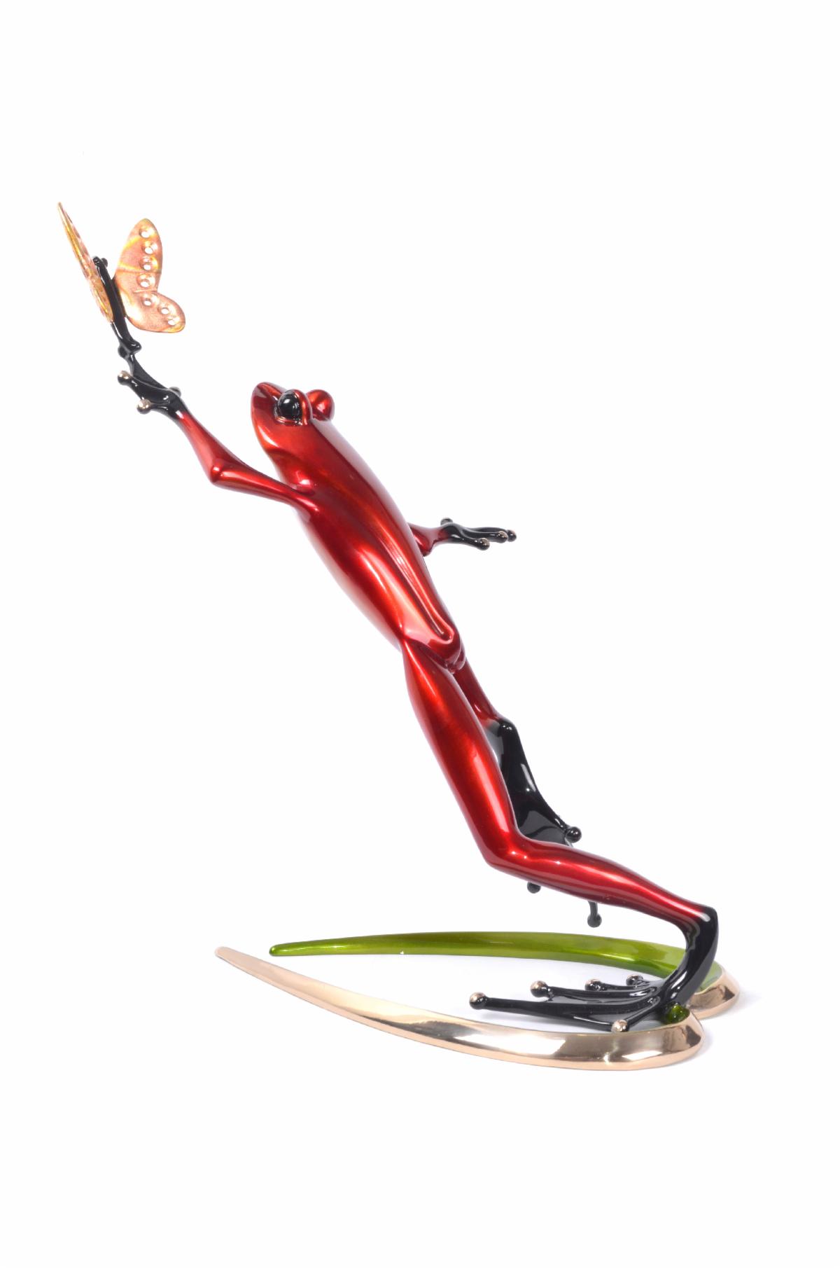 Back view of a sculpture by Frogman featuring a red frog catching a butterfly, called Be Mine.