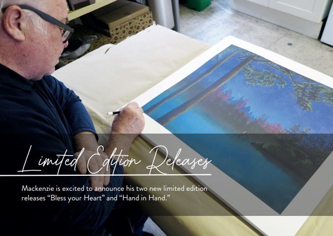 An artist, in their signature style, is focused on a large painting of a serene lake scene with pastel-on-paper hues featuring trees and a colorful sky. Two limited edition releases are titled Bless Your Heart and Hand in Hand.