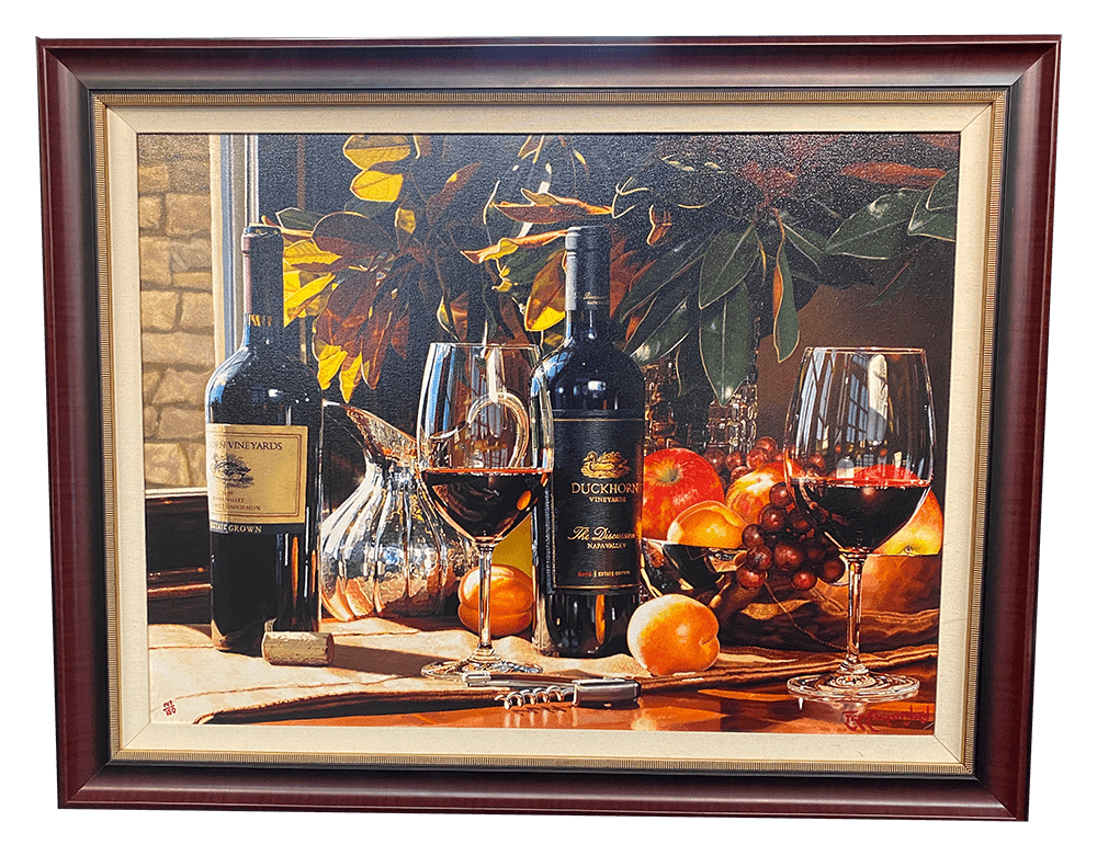 The framed hyper-realism art piece Up for Discussion depicts a table with two wine bottles, three filled glasses, a corkscrew, and assorted fruits such as peaches and grapes, all bathed in radiant sunlight.