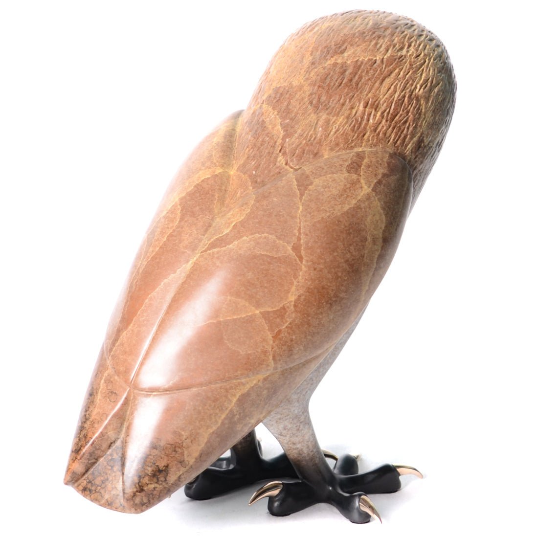 The Churchill sculpture is an owl carved from brown marble, featuring feather-like patterns and detailed talons. It’s positioned with its back to the viewer, highlighting the smooth, polished stonework reminiscent of Tim Cotterills bronze sculptures.