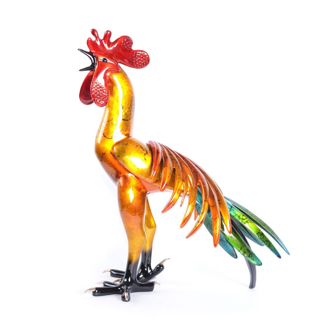 The Cocorico, a colorful glass rooster crafted using Lost Wax casting, features an orange, red, and gold body with blue and green tail feathers. Its detailed comb and wattle stand out against a white background, showcasing a glossy and vibrant look.