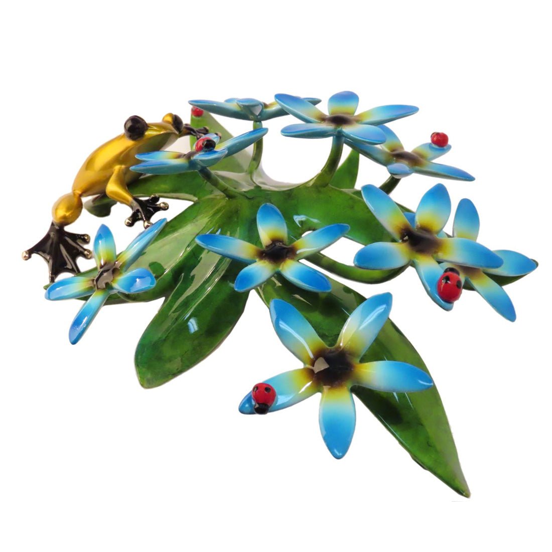 The vibrant Forget-Me-Not art sculpture showcases a yellow and orange frog on green leaves, surrounded by blue and yellow flowers. Two red ladybugs enhance this stunning piece, often displayed in an art gallery.