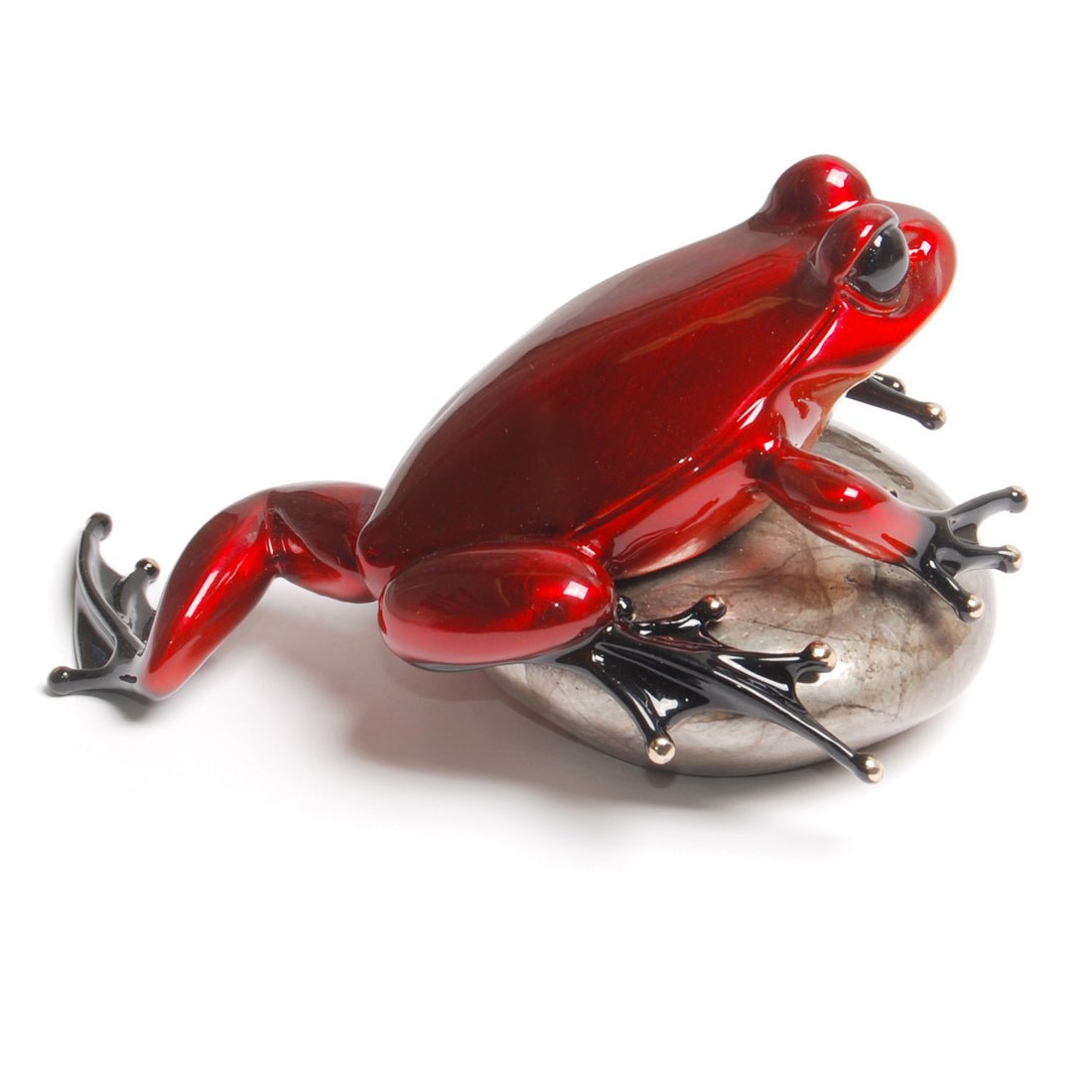 The Rockefeller sculpture features a shiny, red Frogman art perched on a smooth, round, gray stone with glossy black webbed feet. The vibrant colors and textures are beautifully highlighted against a white background, reminiscent of exquisite pieces at Marcus Ashley Gallery.