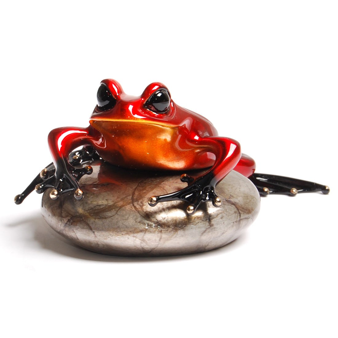 Rockefeller, a shiny, red-orange frog figurine with black feet and large glossy eyes, perches on a smooth stone in an alert stance. Available at Marcus Ashley Gallery, it embodies the elegance of Frogman art and suggests readiness to leap from its marbled perch.