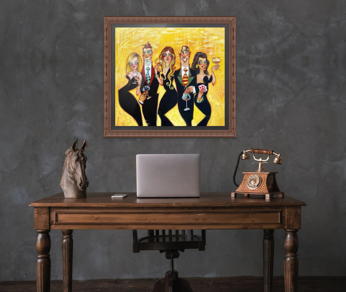 A wooden desk with a laptop, vintage telephone, and horse head sculpture sits before a textured wall. Above it hangs Heights of Your Halos from the Todd White collection, featuring people in black outfits with expressive faces and bright colors. The retro style adds charm to this Limited Edition Release.