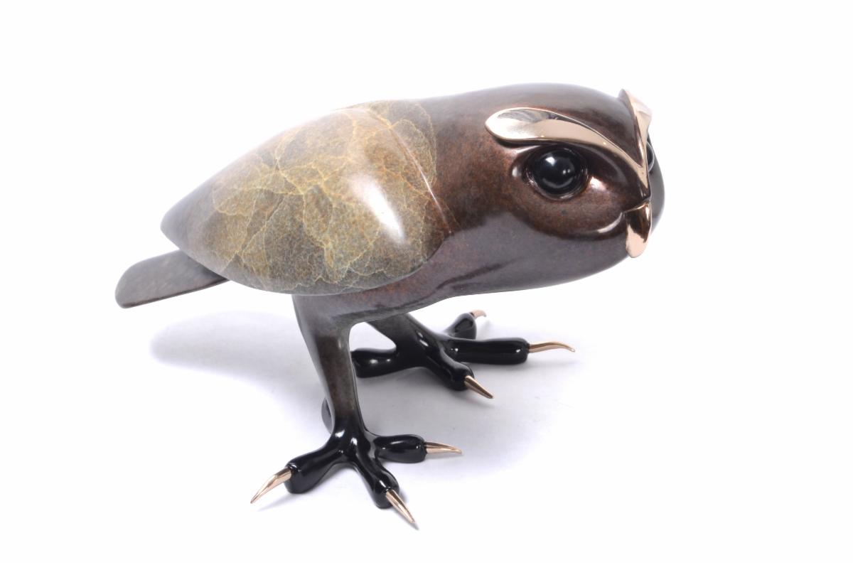 The bronze figurine Hamilton by Tim Cotterill showcases a glossy finish with bronze and golden hues, exaggerated shiny eyes, a metallic beak, and detailed claws, embodying an artistic and modern design.