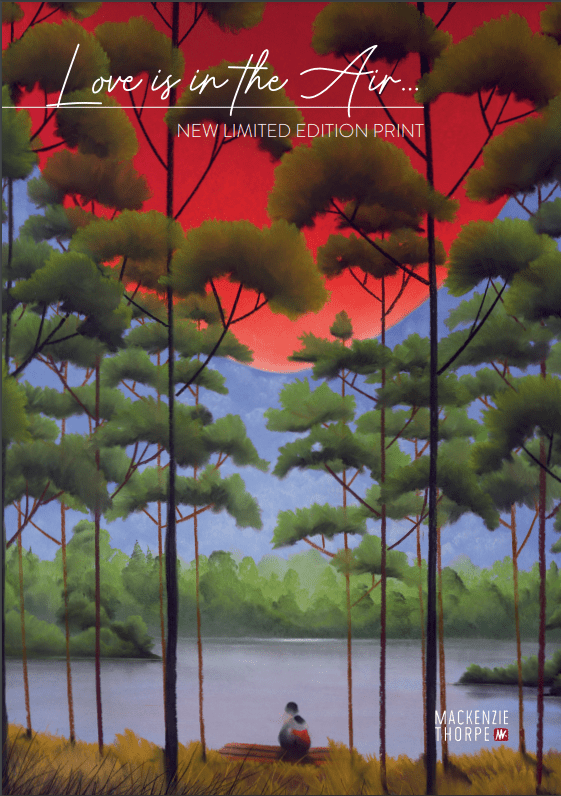 Amid a serene Lake Tahoe landscape with towering trees silhouetted against a vivid red-orange sky, someone sits on a bench by the tranquil water, taking in the view. The image reads Love is in the Air, showcasing Mackenzie Thorpes new limited edition art.