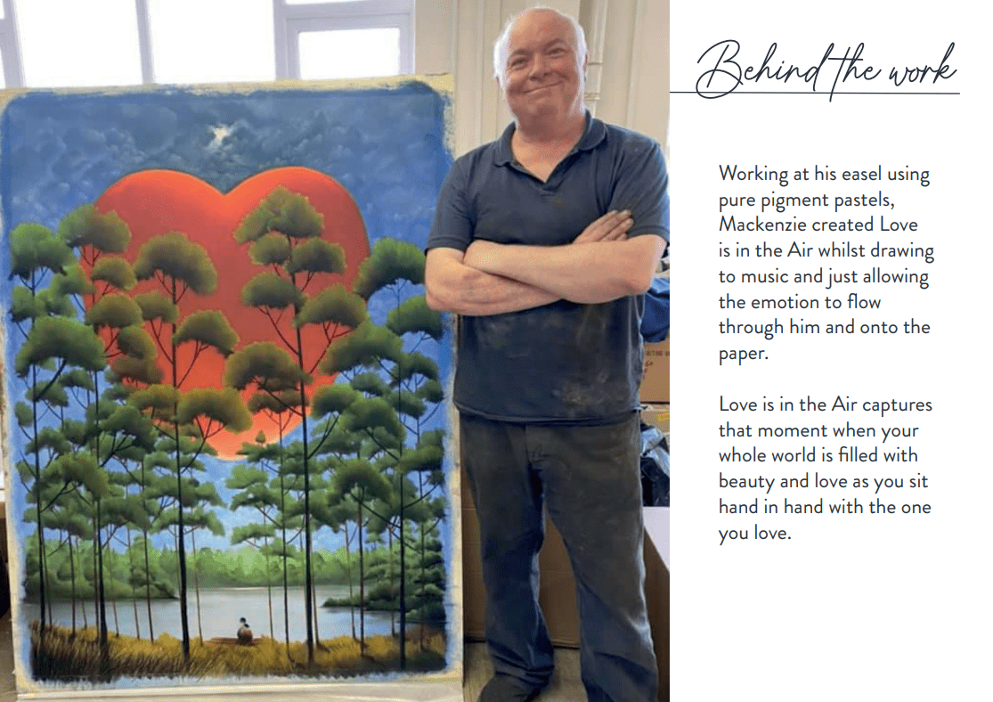An artist smiles beside his vibrant painting, Love is in the Air, featuring tall trees, Lake Tahoe, and a glowing red heart sky. Text describes his pastel technique and inspiration at Marcus Ashley Gallery.