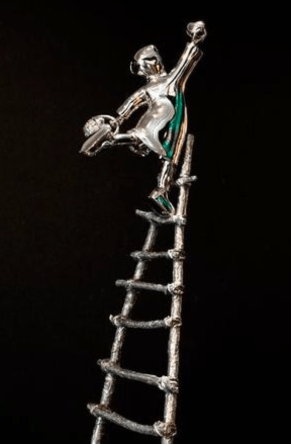 The Love Picker - Stainless is a limited edition silver figurine of a person balancing atop a tall, narrow ladder against a black background, holding a globe and wearing metallic attire with green accents, embodying Mackenzie Thorpes distinct artistry.