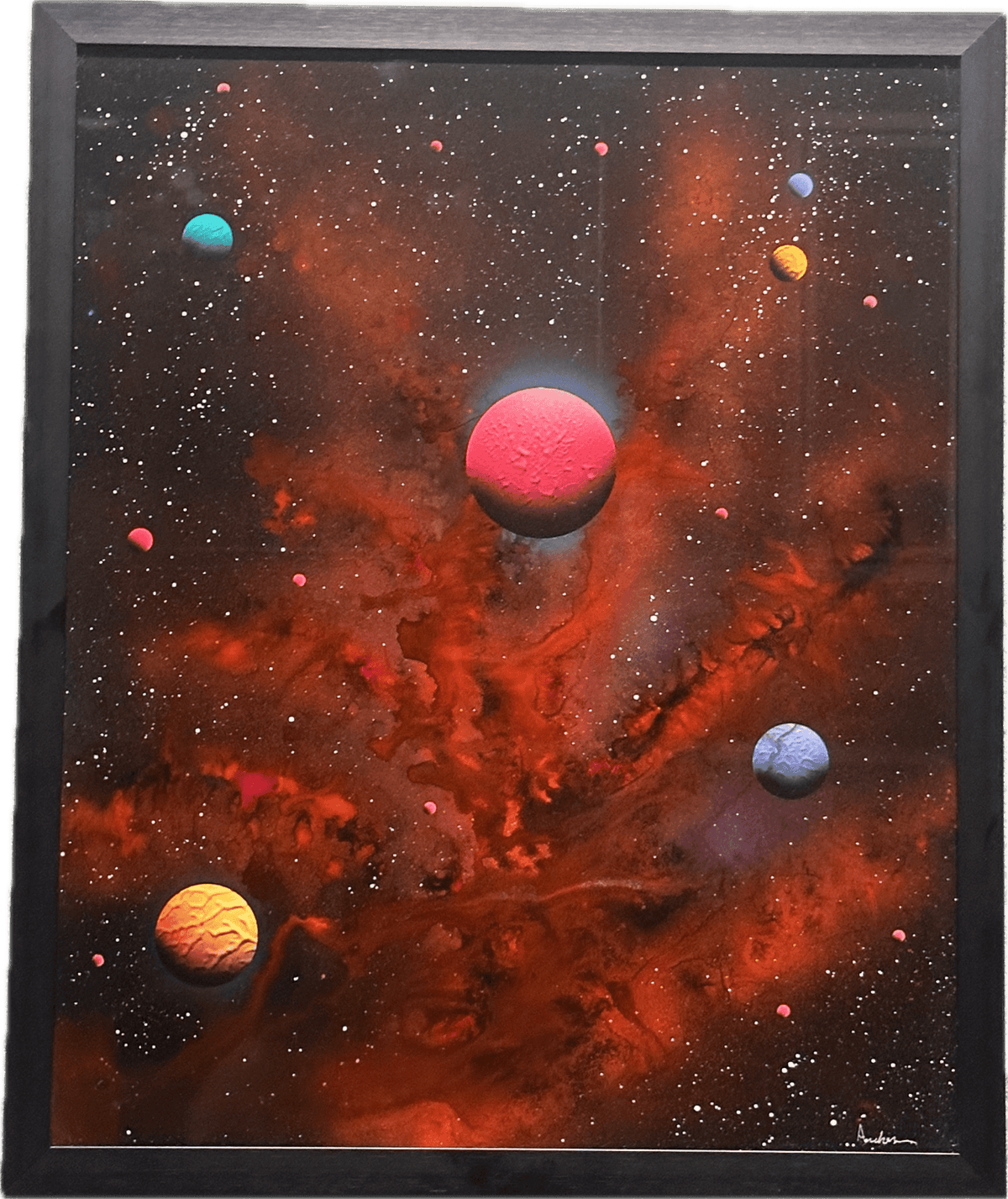 The Many Moons painting depicts a stunning celestial scene with vibrant planets of various sizes amid a swirling red and orange nebula, set against a starry black background.