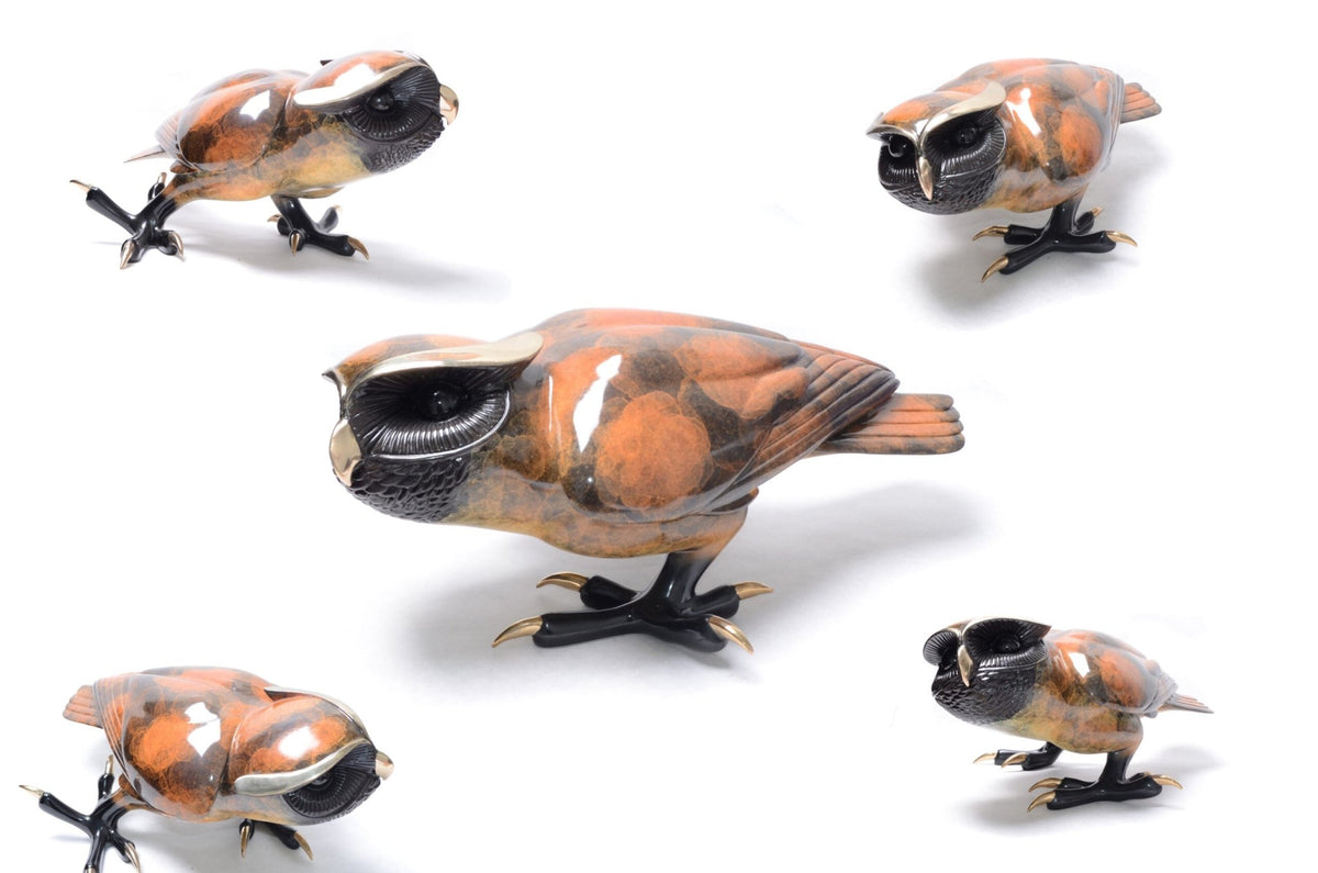 Five intricately designed Shakespeare ceramic owl sculptures in glossy orange, black, and white sit on a white background, each positioned uniquely to showcase diverse angles and details.