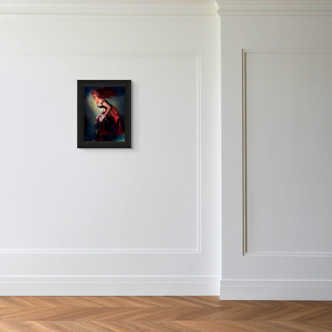 The framed artwork You Know Me Too Well by Gabe Leonard showcases a woman in a red dress and hangs on a white wall with decorative molding, complemented by a minimalist room with an elegant wooden herringbone floor.