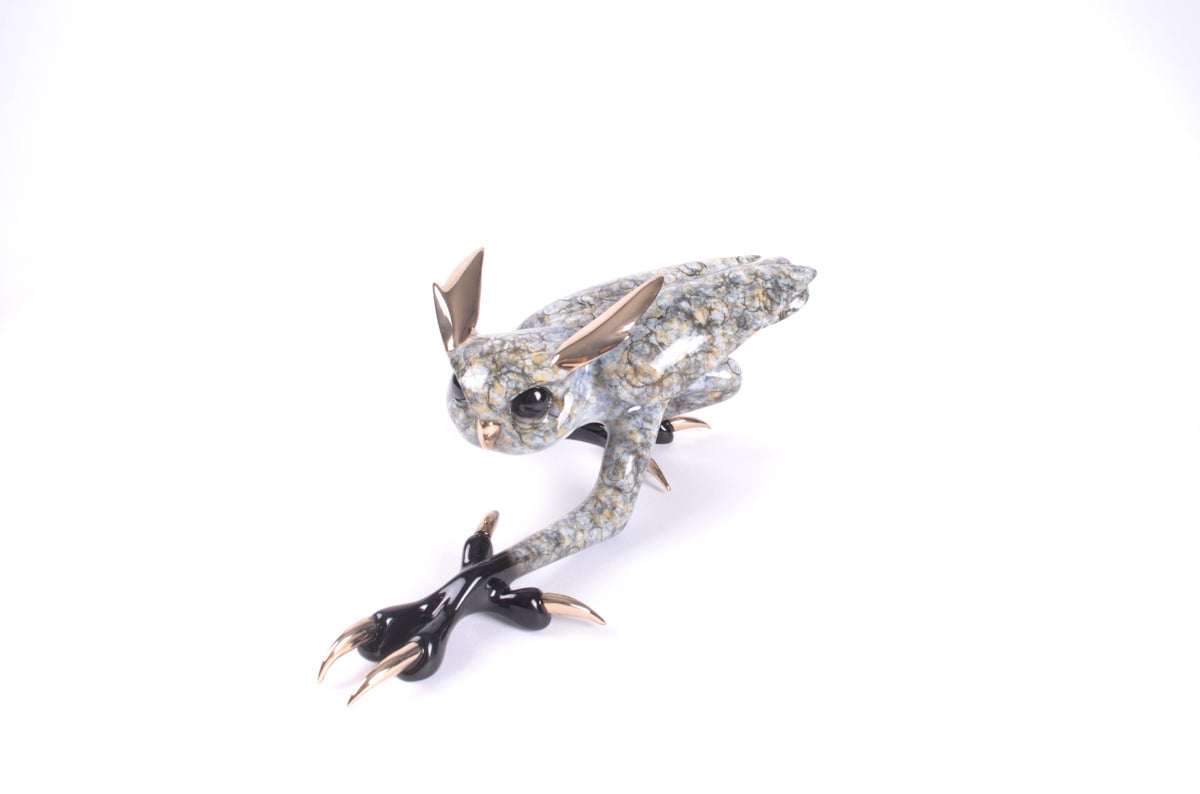 Zeus is a bronze sculpture depicting a fantastical creature with rabbit-like ears, a textured gray and white body, and long black claws, showcased against a plain white background.